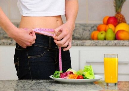 A girl who loses weight on a diet measures her waist size.