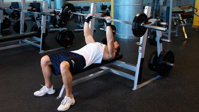 To dry out the shoulders and chest, a barbell bench press is performed on a horizontal bench.